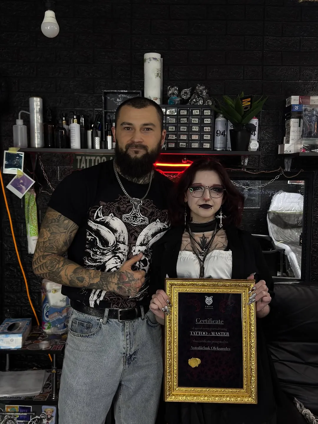 Двоє людей із сертифікатом у тату-студії